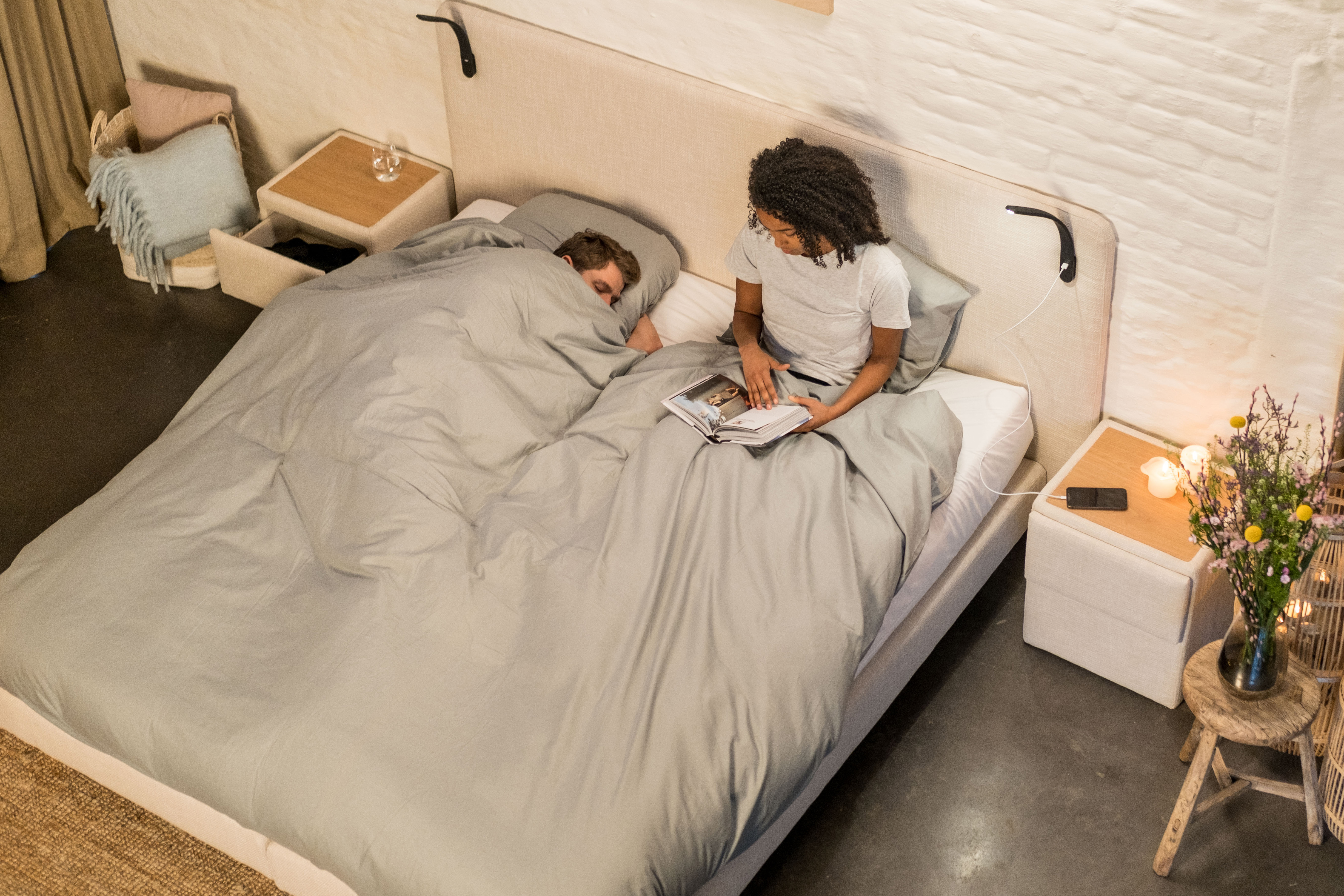 Vrouw die een boek leest terwijl partner slaapt