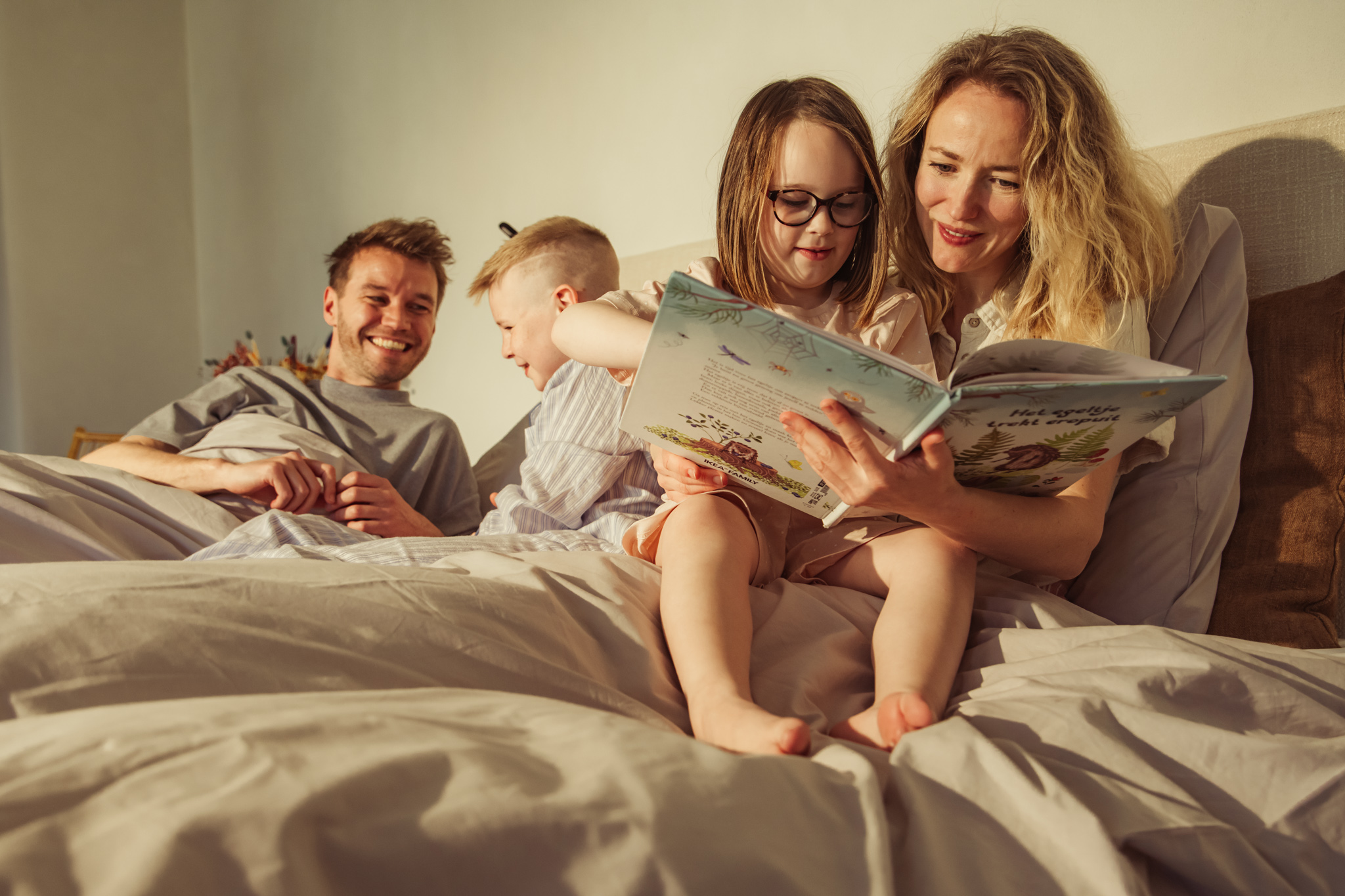 Gezin die samen in bed zitten, praten en lachen
